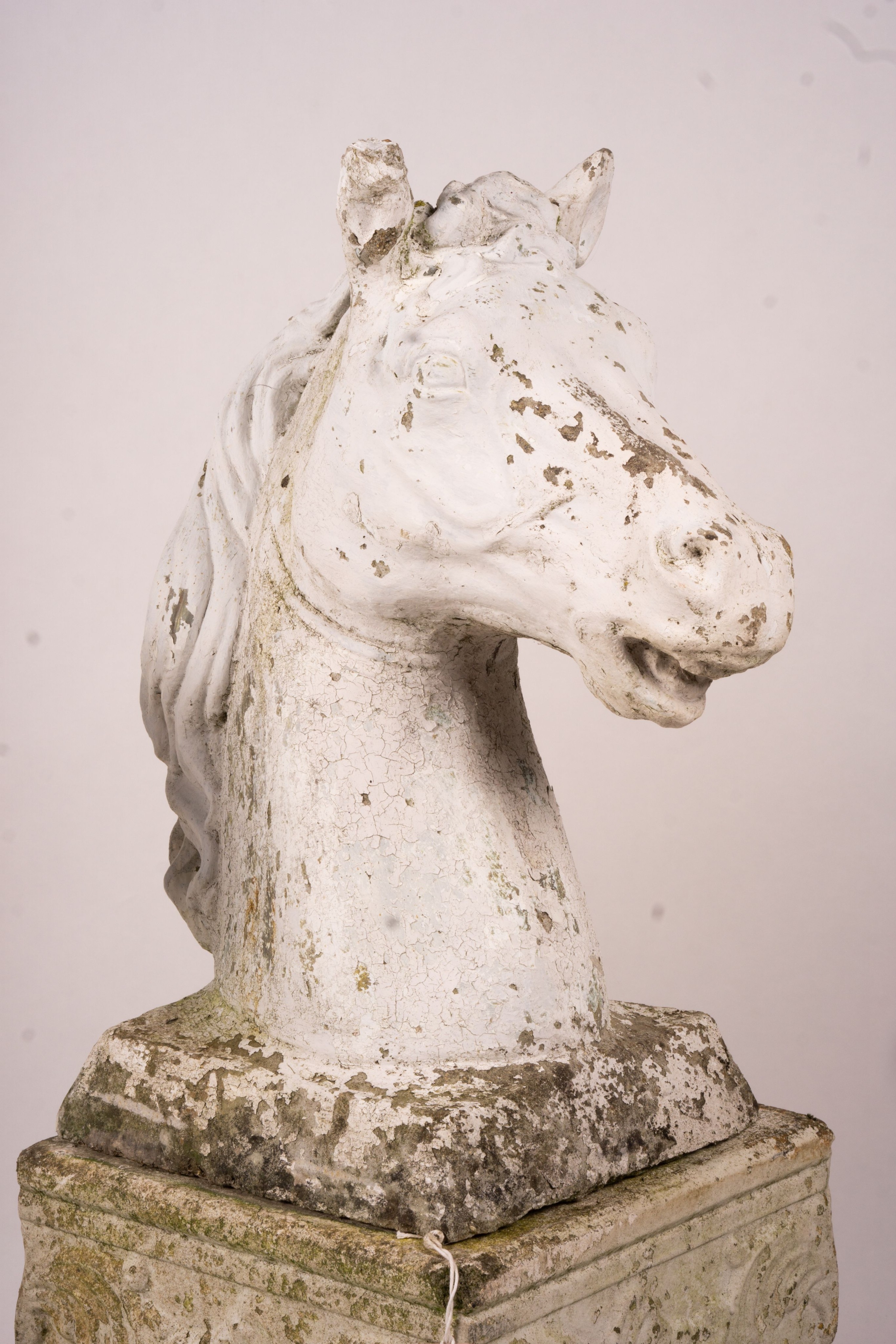 A pair of reconstituted stone horse's heads on plinth bases in the style of Austin and Seeley, height 104cm